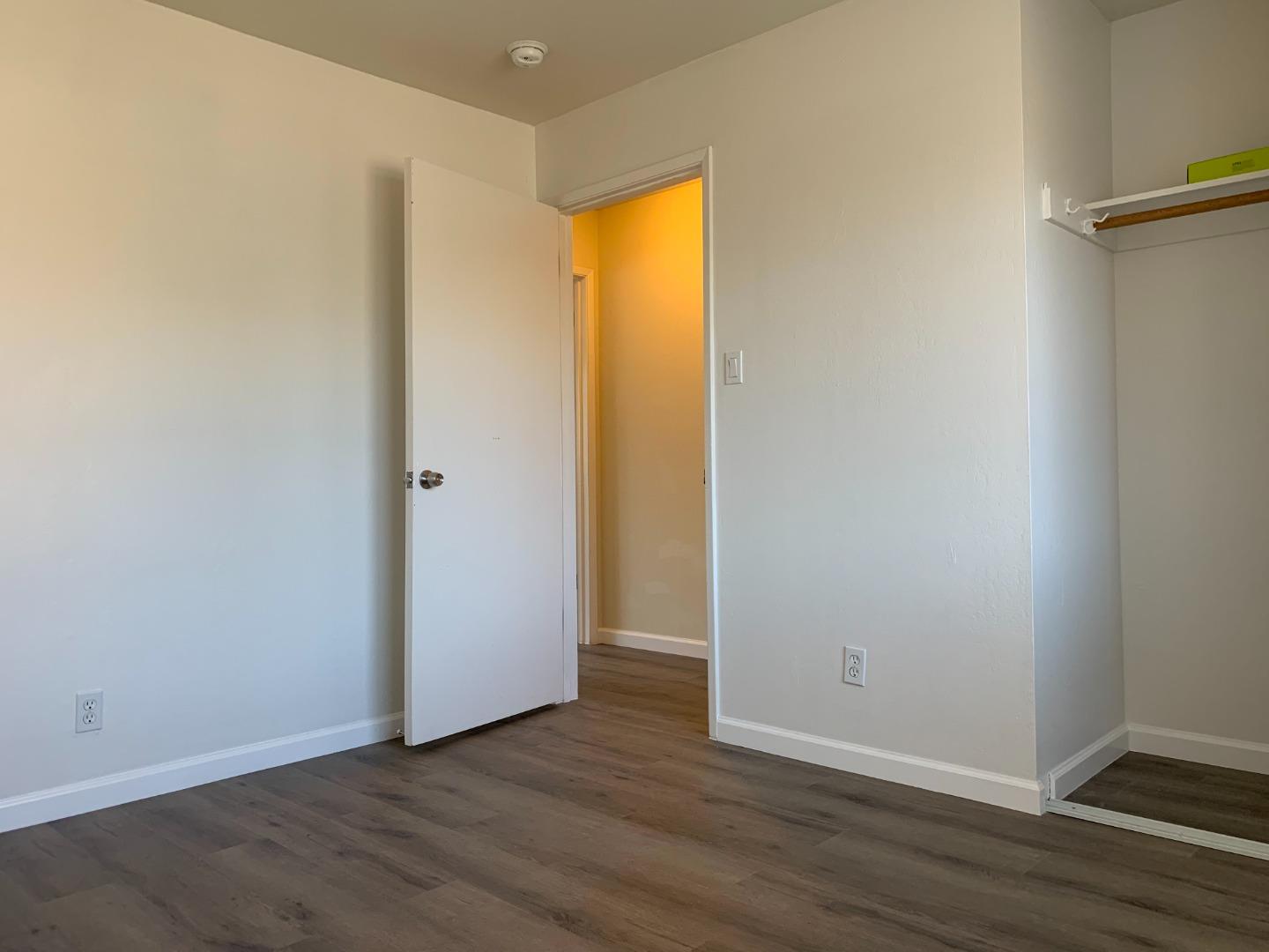 729 Highland Avenue, Unit 3 San Mateo, CA 94401 - Photo 14 of 18 a view of an empty room with wooden floor and a window