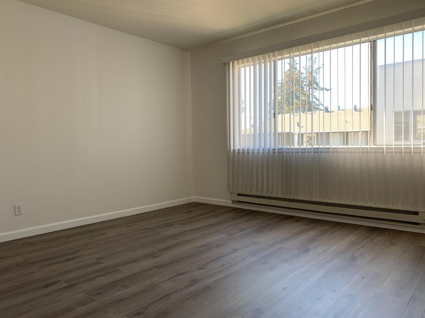 729 Highland Avenue, Unit 3 San Mateo, CA 94401 - Photo 15 of 18 an empty room with wooden floor and windows