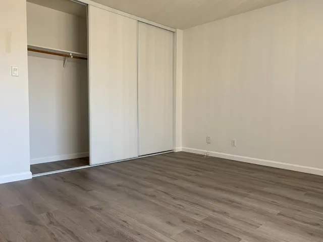 a view of an empty room with wooden floor