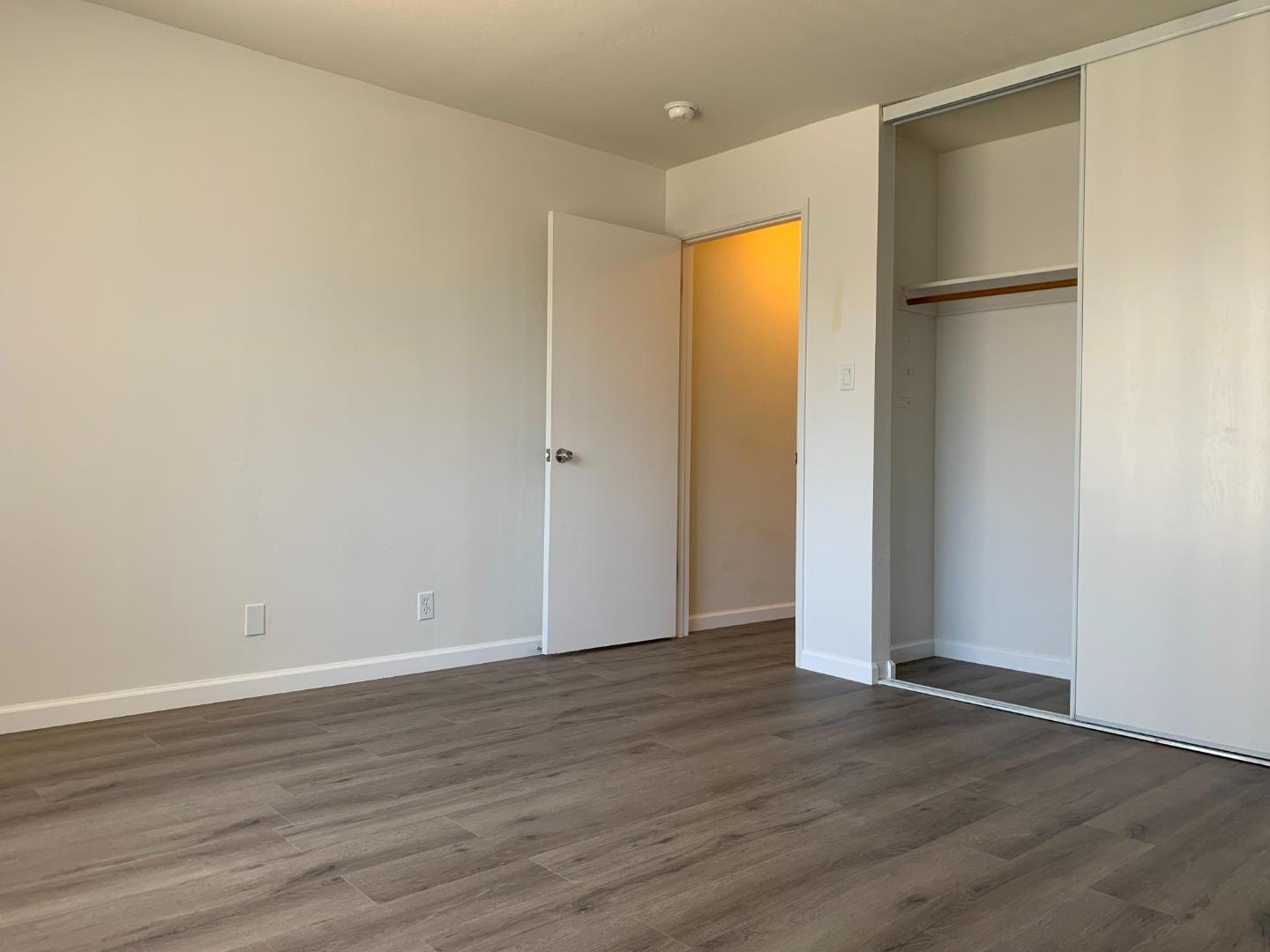 729 Highland Avenue, Unit 3 San Mateo, CA 94401 - Photo 17 of 18 a view of an empty room with wooden floor and a window