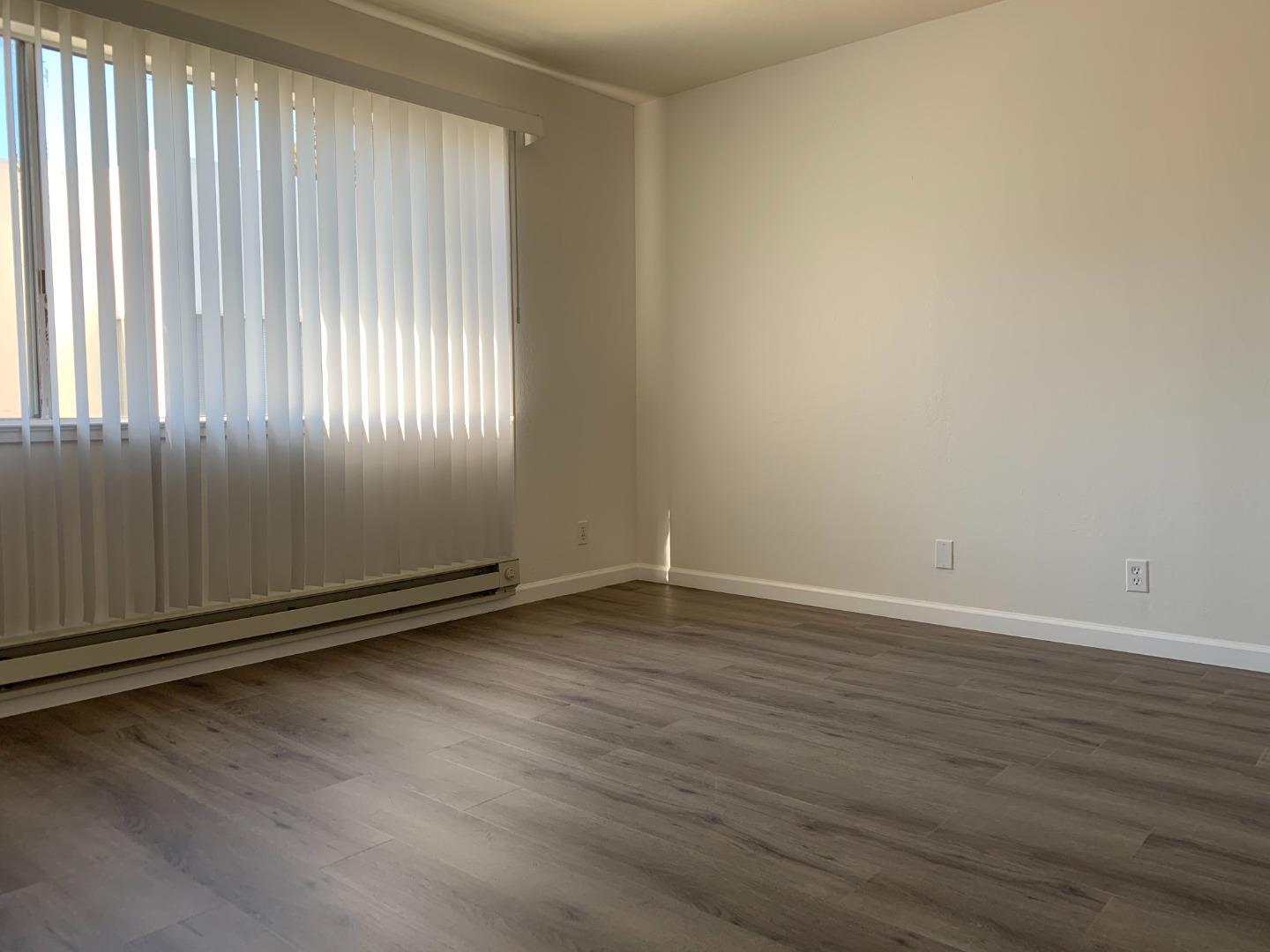 729 Highland Avenue, Unit 3 San Mateo, CA 94401 - Photo 18 of 18 an empty room with wooden floor and windows