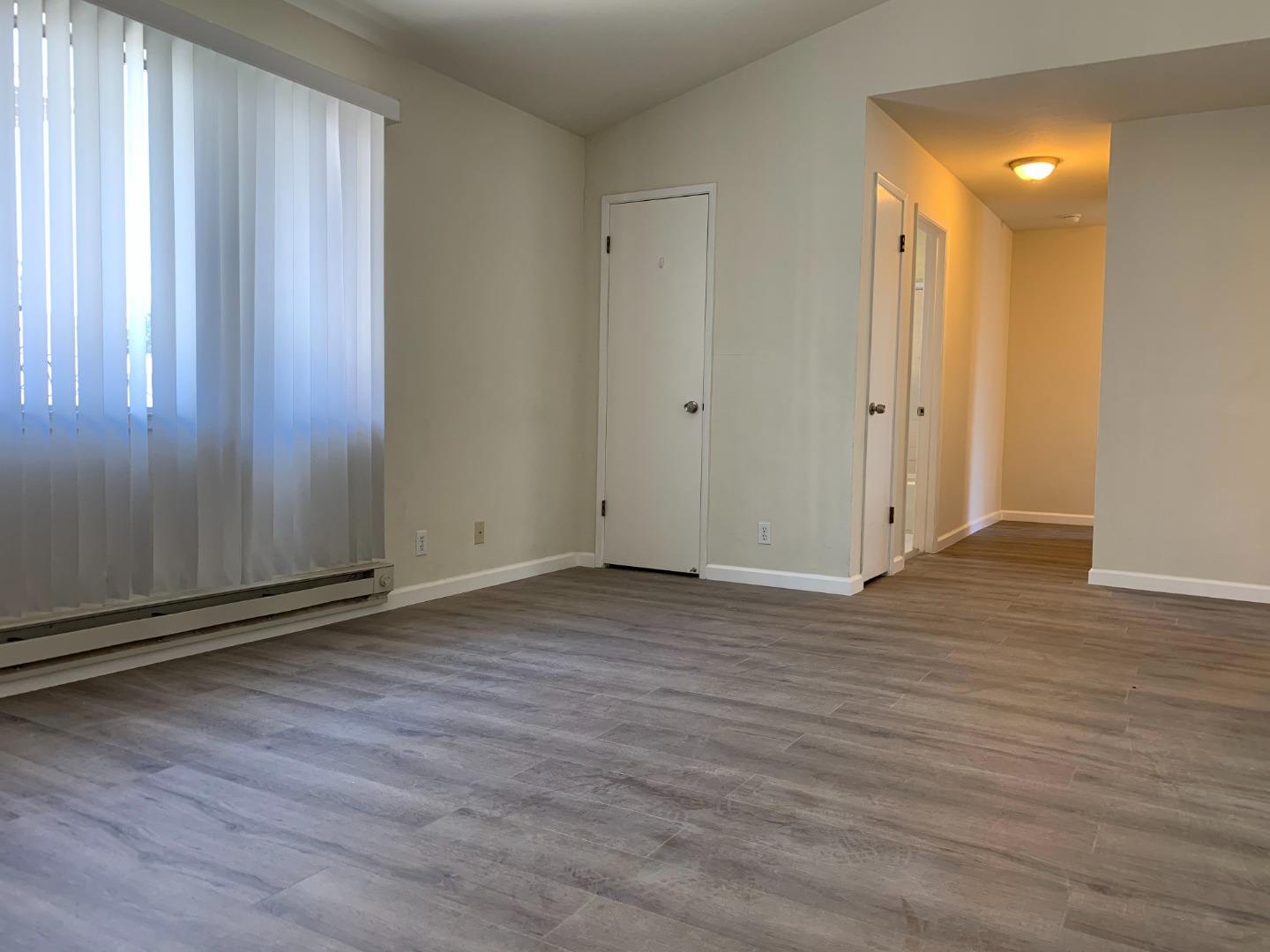 729 Highland Avenue, Unit 3 San Mateo, CA 94401 - Photo 4 of 18 a view of wooden floor and windows in a room