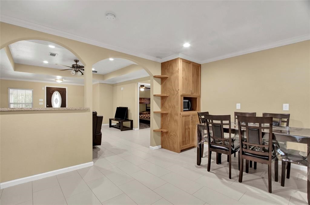 2078 Jeffcote Road Conroe, TX 77303 - Photo 10 of 19 Kitchen with tile flooring, modern stainless steel appliances, and wooden cabinetry. There's a dining area offering a cozy space for meals. The room has a clean, open feel with neutral tones.