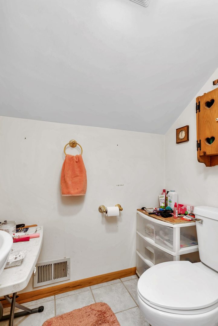 308 San Carlos Road Minooka, IL 60447 - Photo 18 of 25 a bathroom with a sink a toilet and a shower curtain