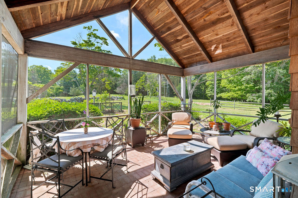 261-1 Grassy Hill Road Lyme, CT 06371 - Photo 31 of 40 The screened porch is a wonderful extension of the living space, perfect for savoring morning coffee, summer dinners, and serene evenings overlooking the beauty of the property.