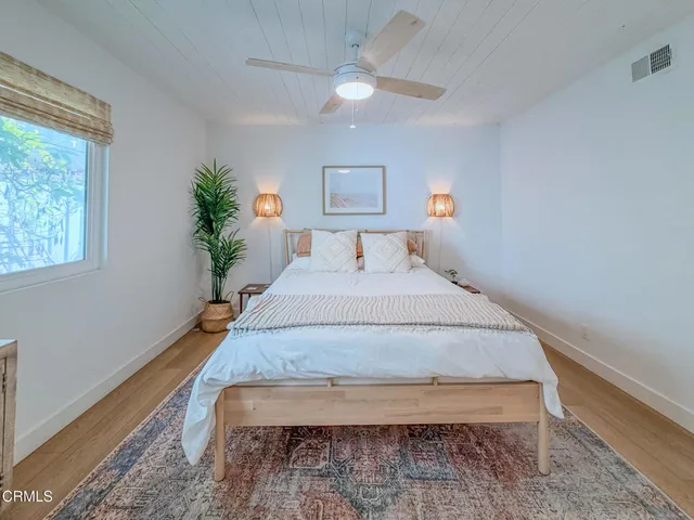 a bedroom with a bed and a potted plant