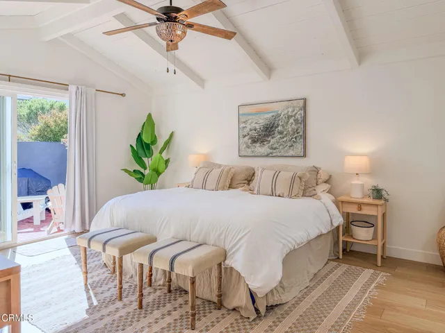 a large white bed sitting in a bedroom next to a window