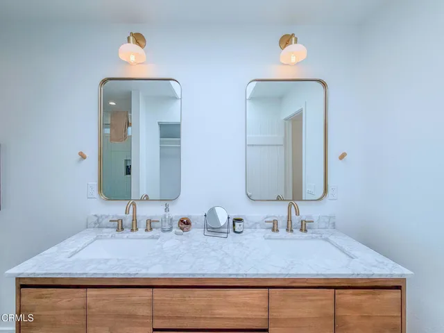 a bathroom with double vanity sinks and a mirror