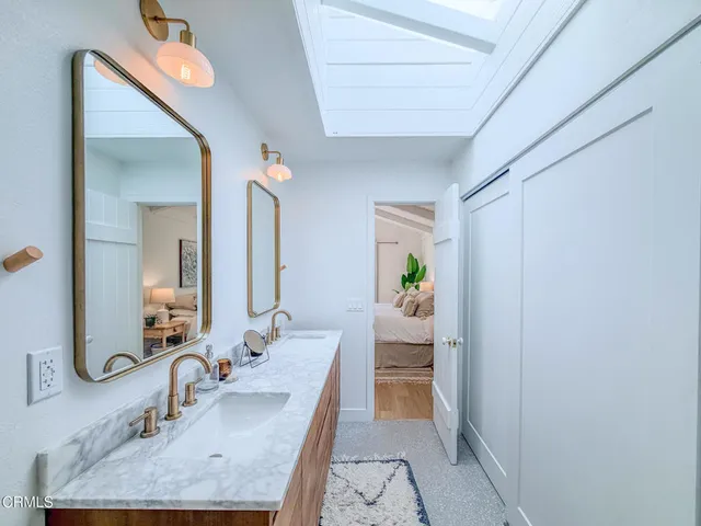 a en suite bathroom with a granite countertop sink and a mirror