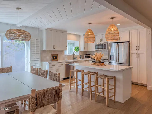 a kitchen with stainless steel appliances granite countertop a stove a sink dishwasher and a refrigerator with wooden floor