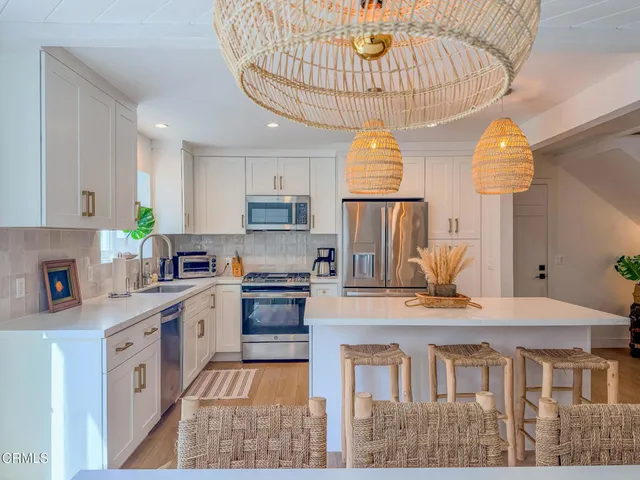 a kitchen with kitchen island granite countertop a stove a sink a counter space and cabinets