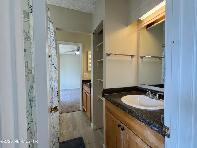 an empty room with closet and a ceiling fan