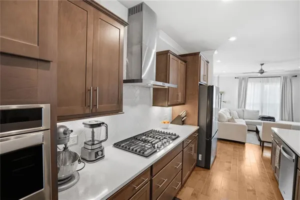 a large kitchen with a center island wooden floor stainless steel appliances and cabinets