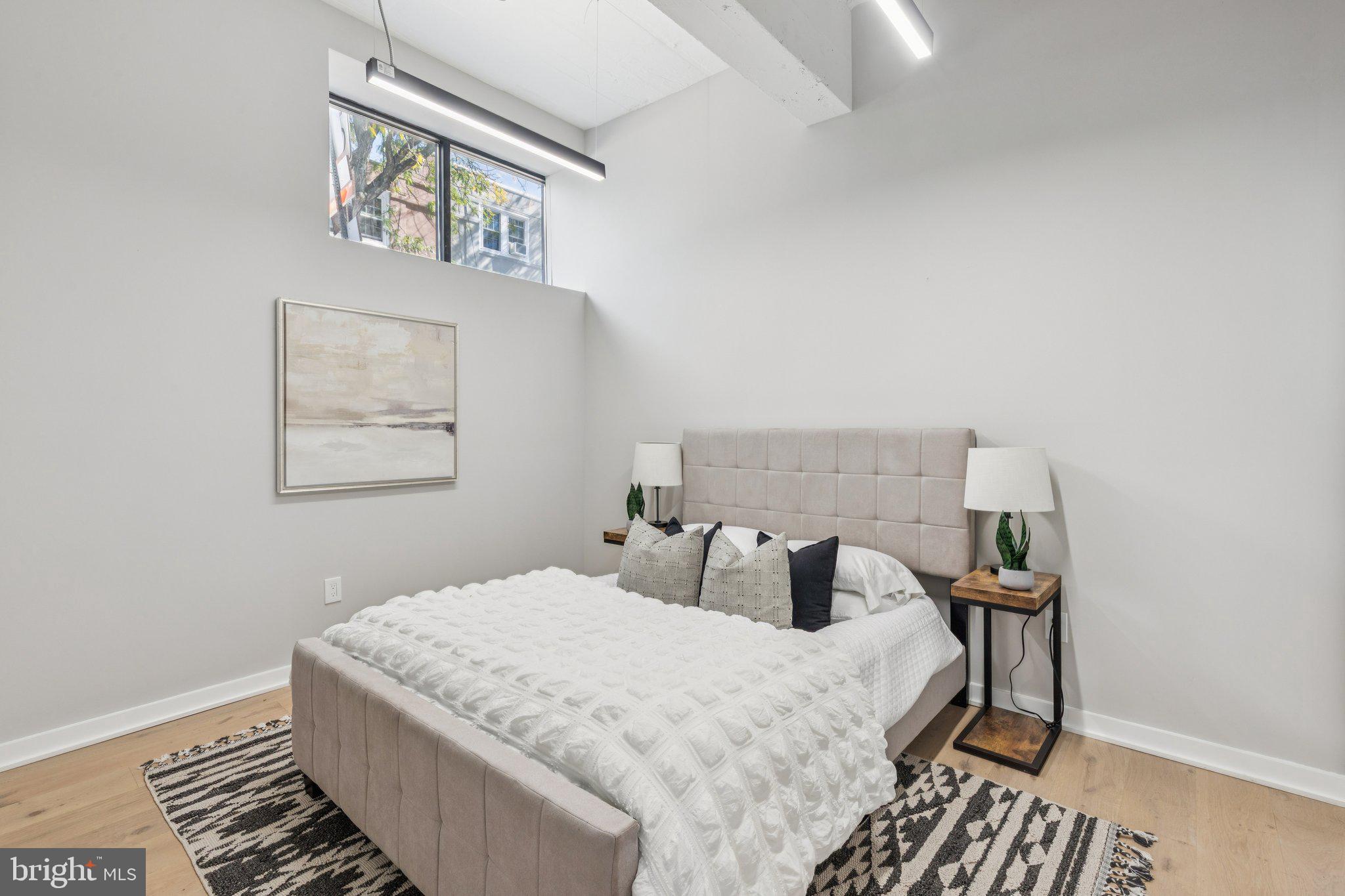 36 North Narberth Avenue, Unit 1C Narberth, PA 19072 - Photo 13 of 36 a bedroom with a bed and a lamp on table