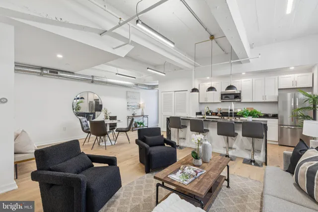a living room with lots of furniture and kitchen view