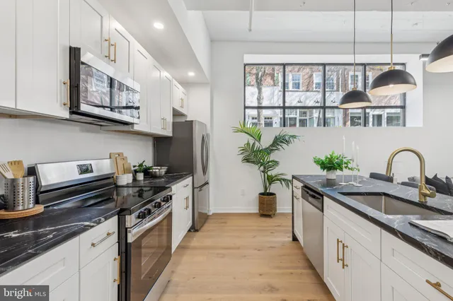 a kitchen with stainless steel appliances granite countertop a stove a sink and a refrigerator