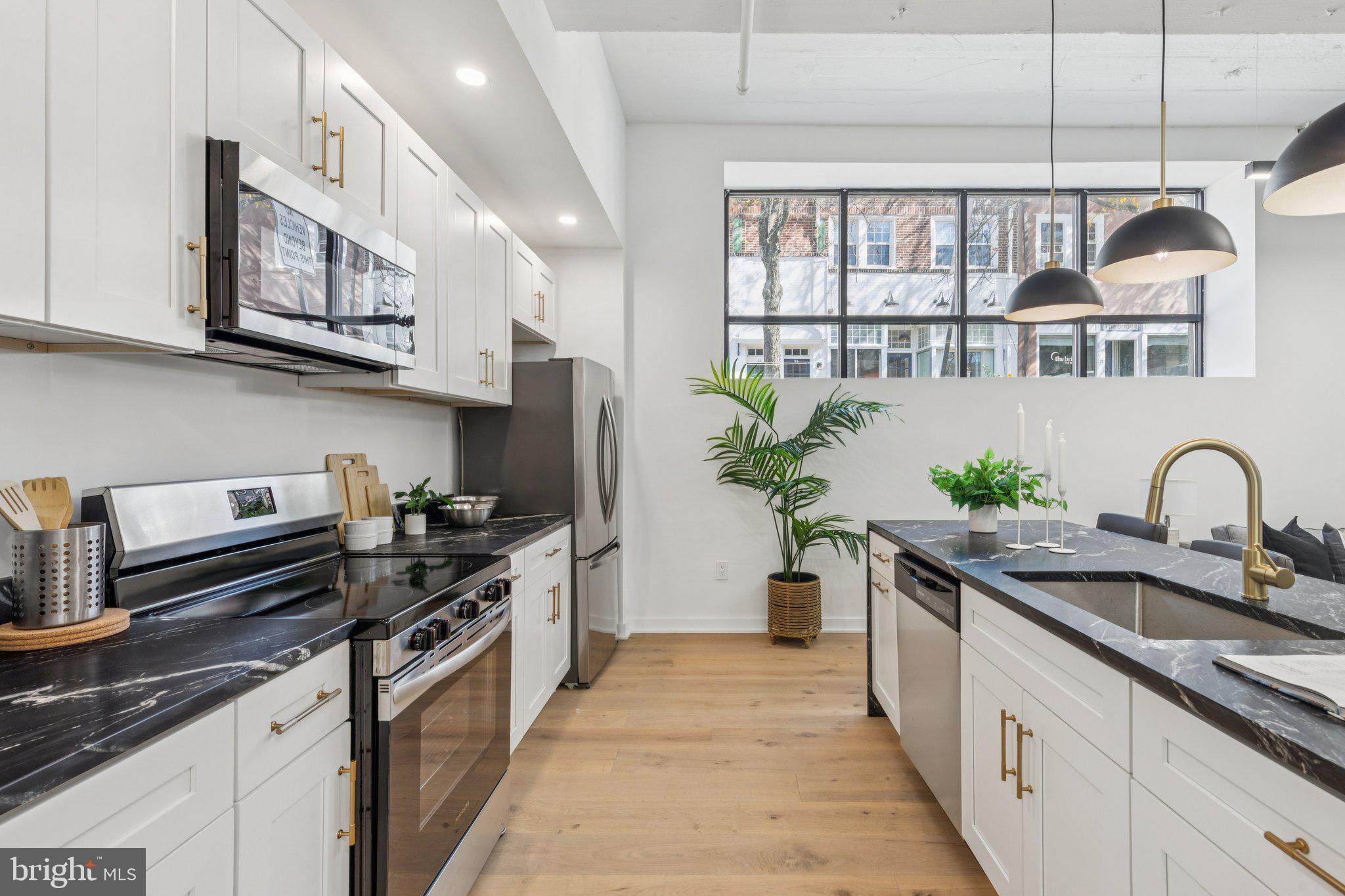 36 North Narberth Avenue, Unit 1C Narberth, PA 19072 - Photo 28 of 36 a kitchen with stainless steel appliances granite countertop a stove a sink and a refrigerator
