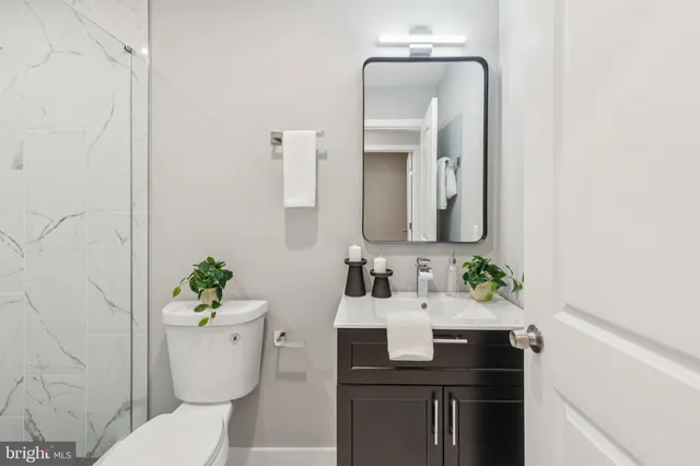 a bathroom with a toilet sink and mirror