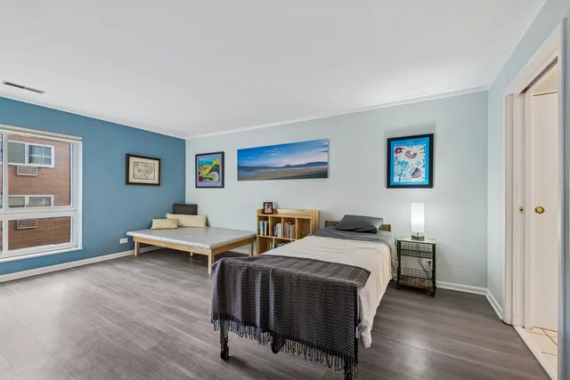a bedroom with two beds and wooden floor