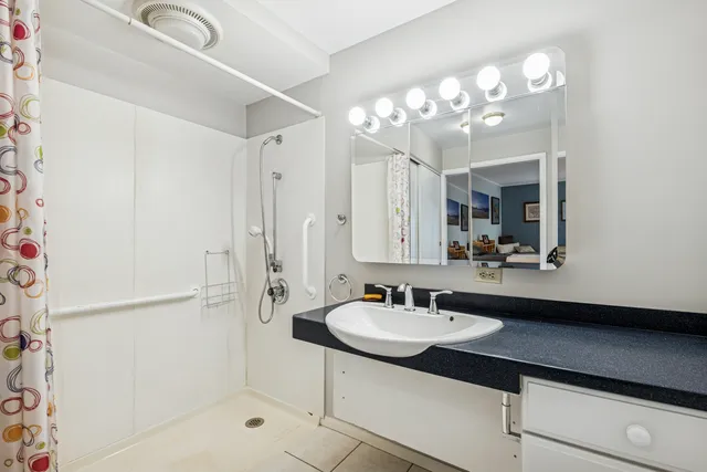 a bathroom with a sink shower and a mirror