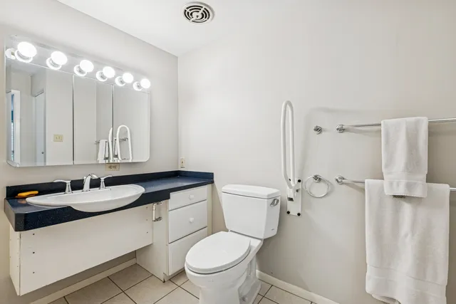 a bathroom with a granite countertop sink a toilet and a mirror