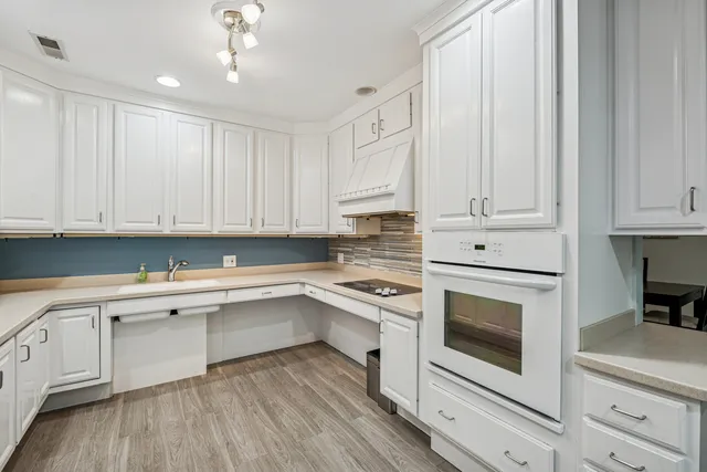 a kitchen with white cabinets and white appliances