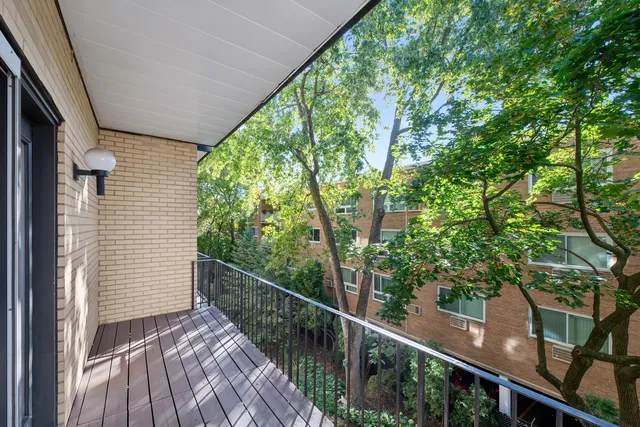 a view of a balcony with wooden floor and fence