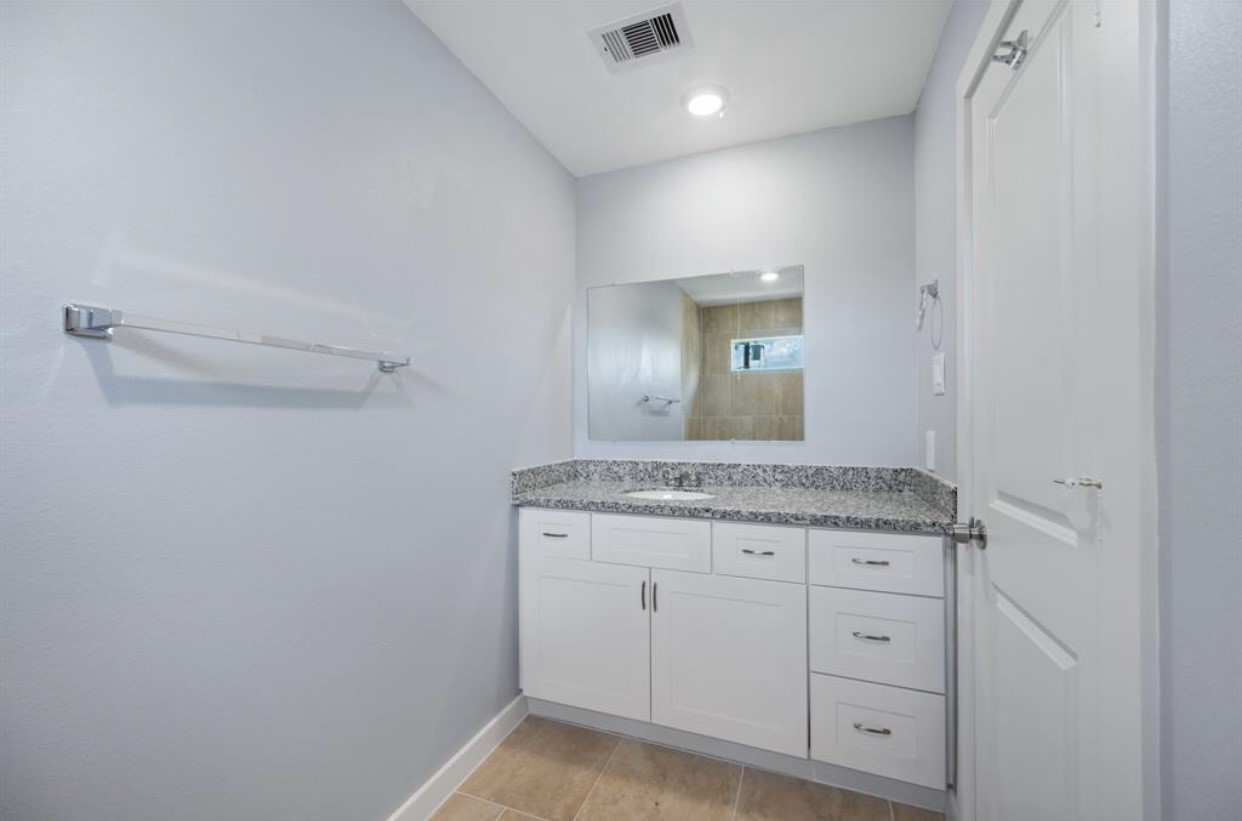 622 Maple Way Houston, TX 77015 - Photo 17 of 19 a bathroom with a granite countertop sink and a mirror