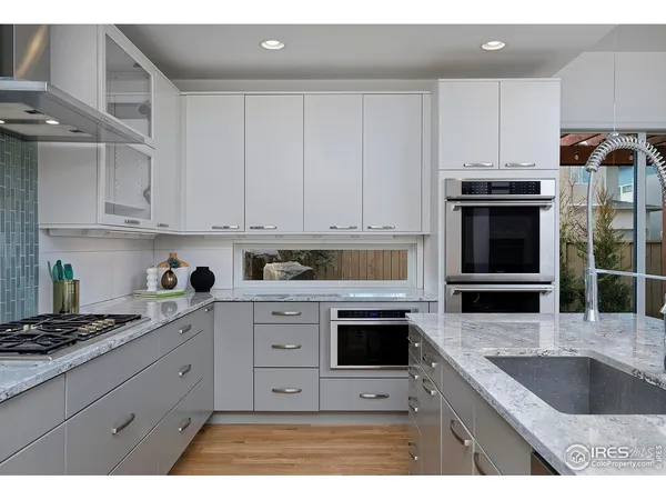 a kitchen with granite countertop a stove sink and cabinets