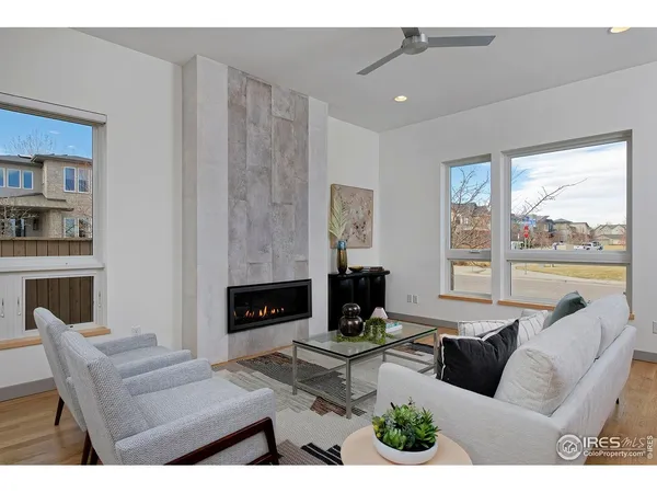 a living room with furniture a fireplace and a floor to ceiling window
