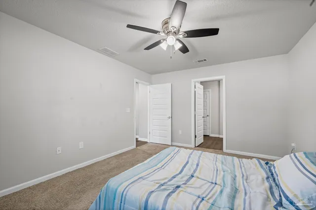 a bedroom with a large bed and a chandelier