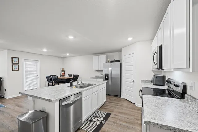 a kitchen with stainless steel appliances granite countertop a sink stove and refrigerator