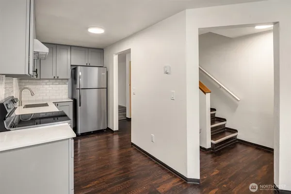 a kitchen with a refrigerator and a stove top oven