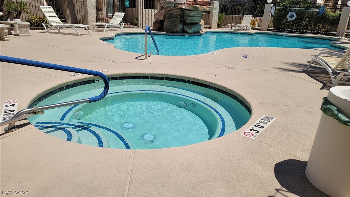 1851 Hillpointe Road, Unit 1022 Henderson, NV 89074 - Photo 6 of 8 An inviting community pool with an integrated spa awaits, framed by lounge seating and a decorative rock feature.