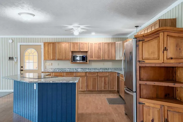 a kitchen with stainless steel appliances granite countertop a sink stove and refrigerator