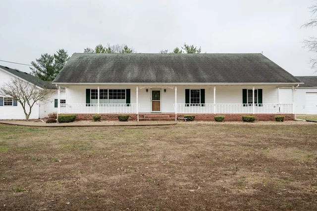 a front view of house with yard and trees in the background