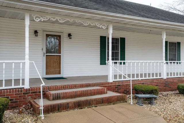 front view of a house with a chair and a floor to ceiling window