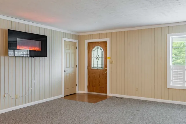 a view of an empty room with window and bathroom