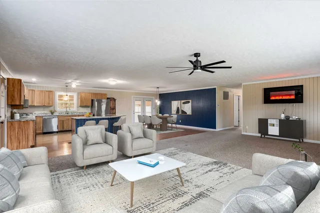 a large kitchen with a large counter top a sink stainless steel appliances and cabinets