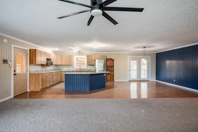 a kitchen with stainless steel appliances granite countertop a refrigerator and wooden cabinets