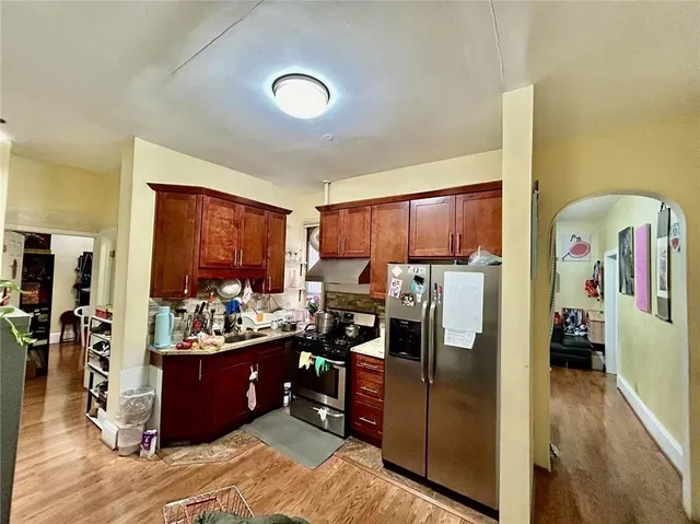 a kitchen with stainless steel appliances kitchen island granite countertop a refrigerator and a sink