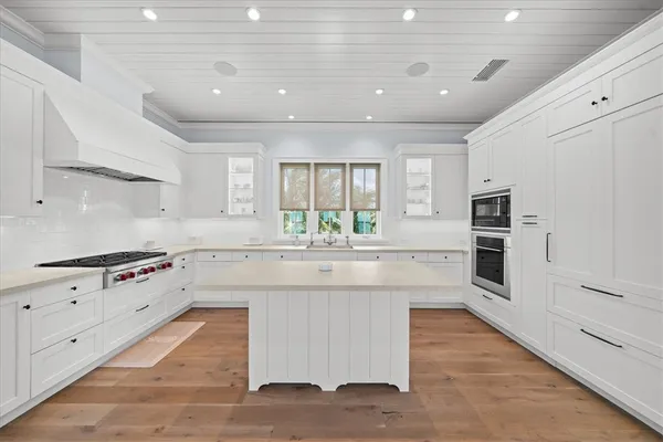 a large kitchen with stainless steel appliances granite countertop a stove and a sink