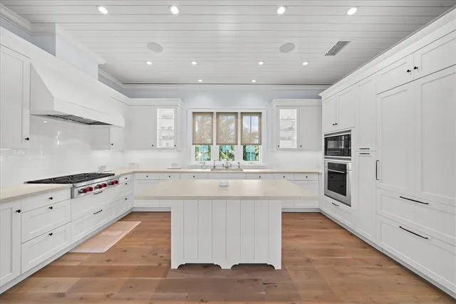 a large kitchen with stainless steel appliances granite countertop a stove and a sink