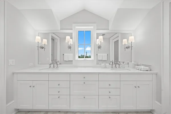a bathroom with double sink and a mirror
