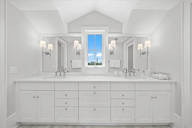 a bathroom with double sink and a mirror