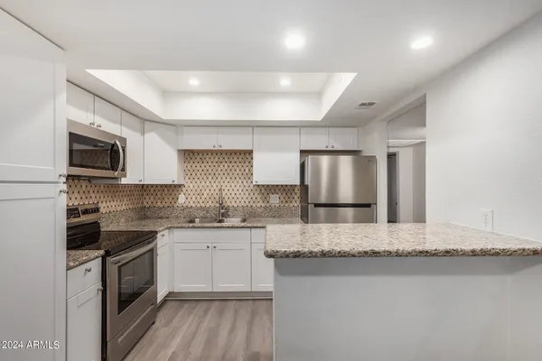 a kitchen with stainless steel appliances granite countertop a sink stove and microwave