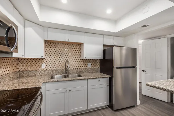 a kitchen with a refrigerator sink and cabinets