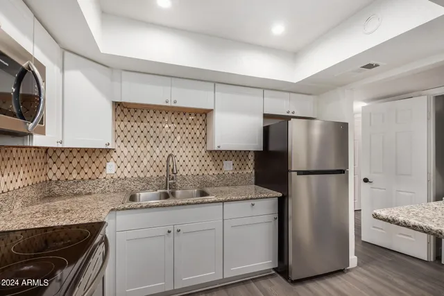 a kitchen with a refrigerator sink and cabinets