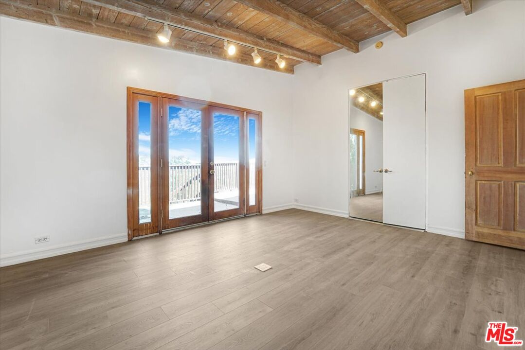 960 North Tigertail Road Los Angeles, CA 90049 - Photo 11 of 21 a view of an empty room with wooden floor and a window