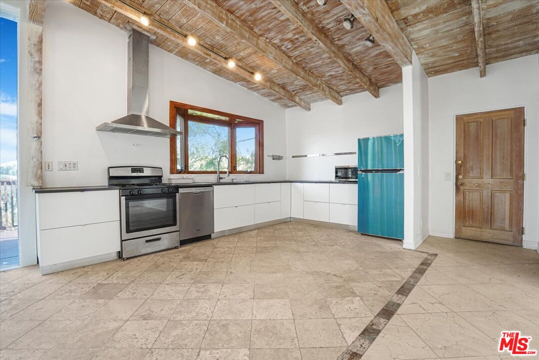 960 North Tigertail Road Los Angeles, CA 90049 - Photo 9 of 21 a kitchen with stainless steel appliances granite countertop a refrigerator and a stove top oven